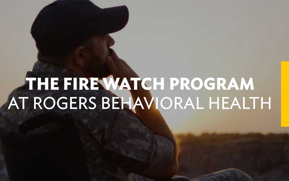 Man in a wheelchair, wearing military attire, gazes at the sunset. Text reads, "The Fire Watch Program at Rogers Behavioral Health.