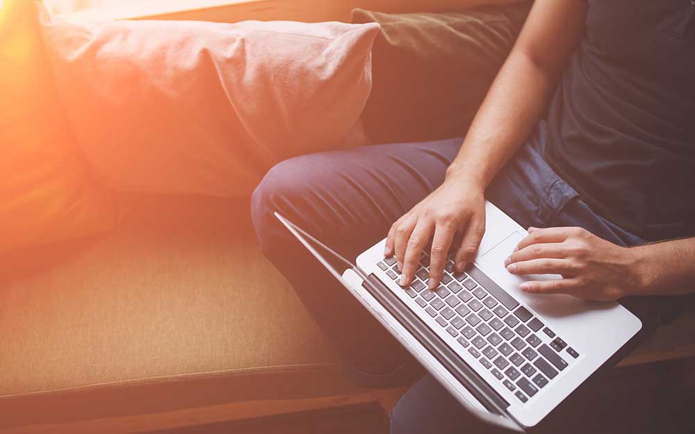 Hands typing on a laptop keyboard